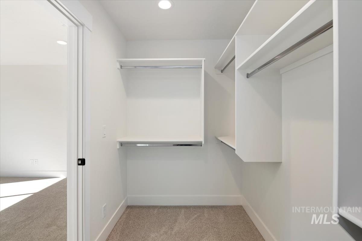 752 South Calhoun Lane Star, ID 83669 - Photo 22 of 45 Walk-in closet featuring built-in shelving, hanging rods, recessed lighting, and carpet flooring