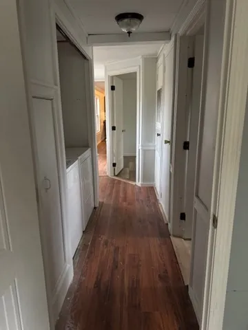 a view of a hallway with wooden floor and staircase