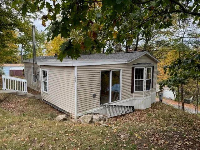 a view of a house with a yard and large tree
