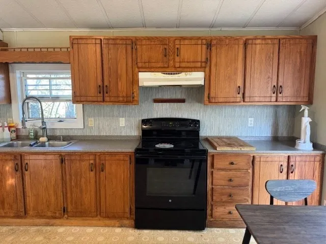 a kitchen with granite countertop a stove a sink and a cabinets