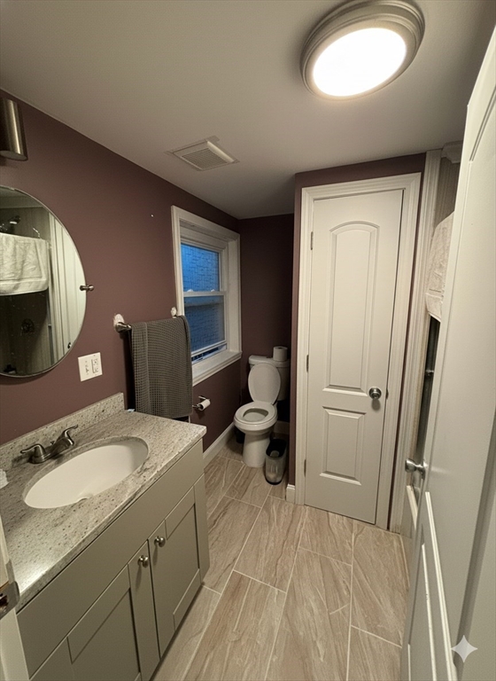 10 Riverbank Road, Unit 2 Maynard, MA 01754 - Photo 4 of 13 a bathroom with a sink a toilet a mirror and vanity