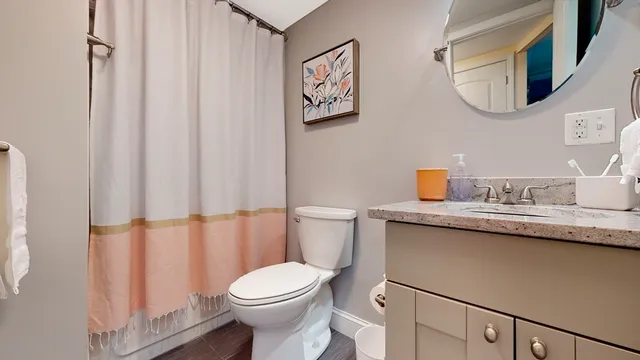 a bathroom with a granite countertop sink mirror vanity and toilet