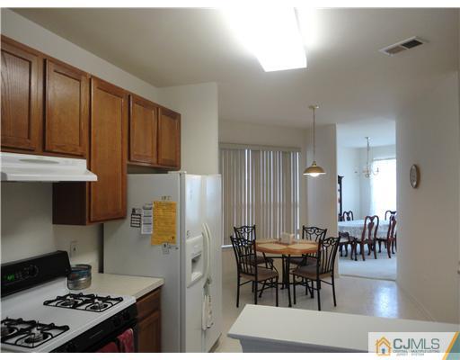 57 Timber Ridge Road North Brunswick, NJ 08902 - Photo 8 of 25 a kitchen with granite countertop a stove a refrigerator and dining table