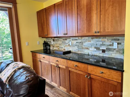 a kitchen with stainless steel appliances granite countertop wooden cabinets a sink and a white countertops with wooden floor