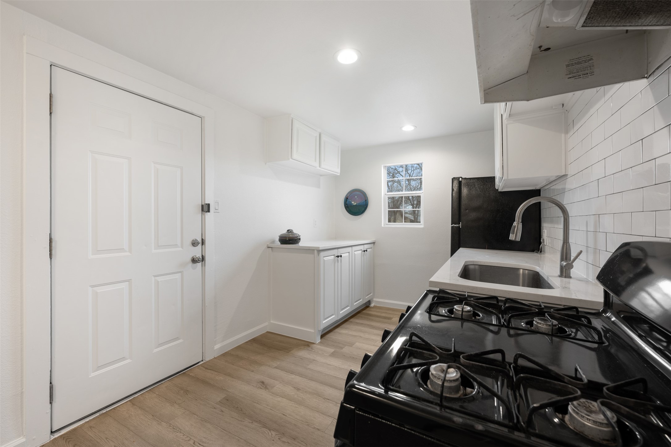 901 Valdez Street, Unit 13 Austin, TX 78741 - Photo 12 of 38 a kitchen with a stove and a wooden floor