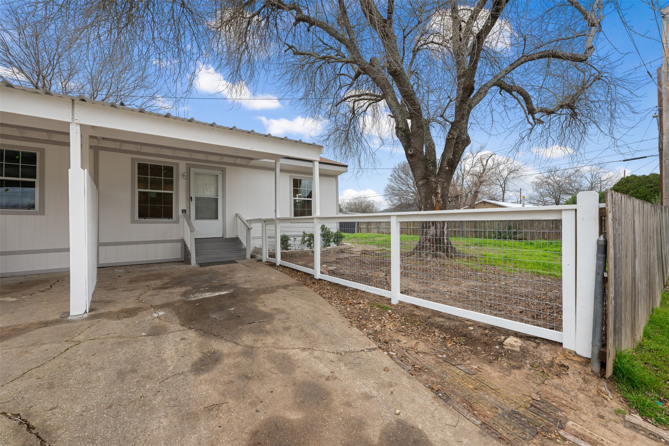 901 Valdez Street, Unit 13 Austin, TX 78741 - Photo 3 of 38 a view of backyard with large trees and wooden fence