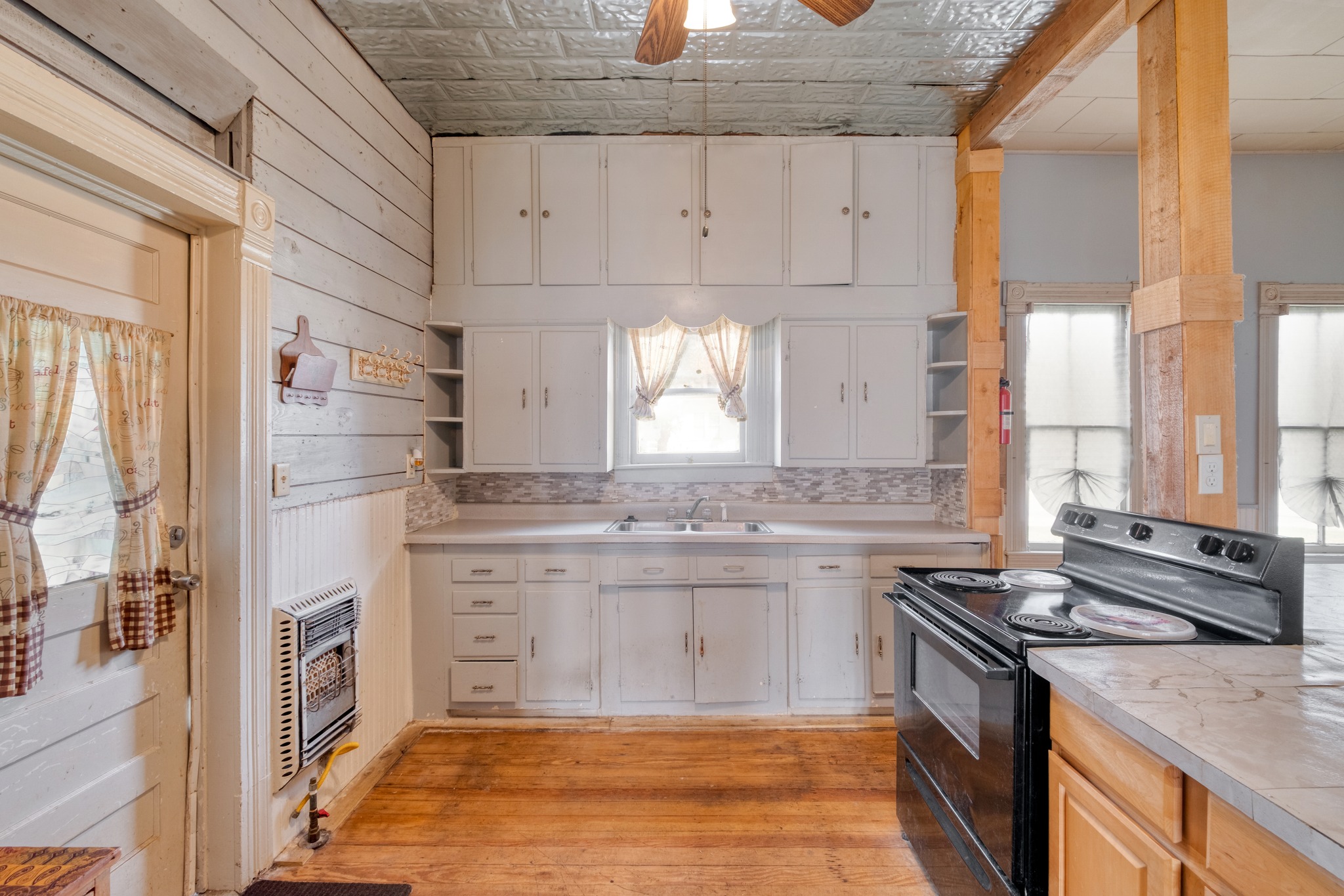 300 South Rio Grande Street Granger, TX 76530 - Photo 13 of 25 Kitchen featuring open shelves, black electric range oven, an ornate ceiling, light countertops, and a ceiling fan