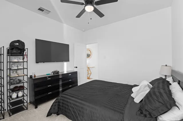 a bedroom with a bed and a flat tv screen on the dresser