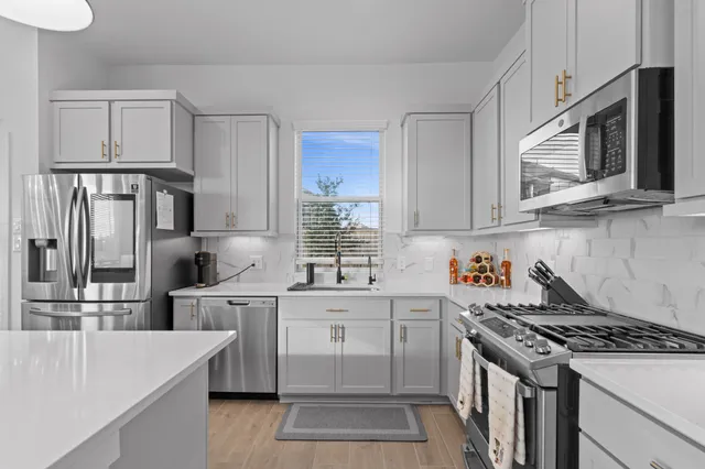 a kitchen with appliances a sink and cabinets