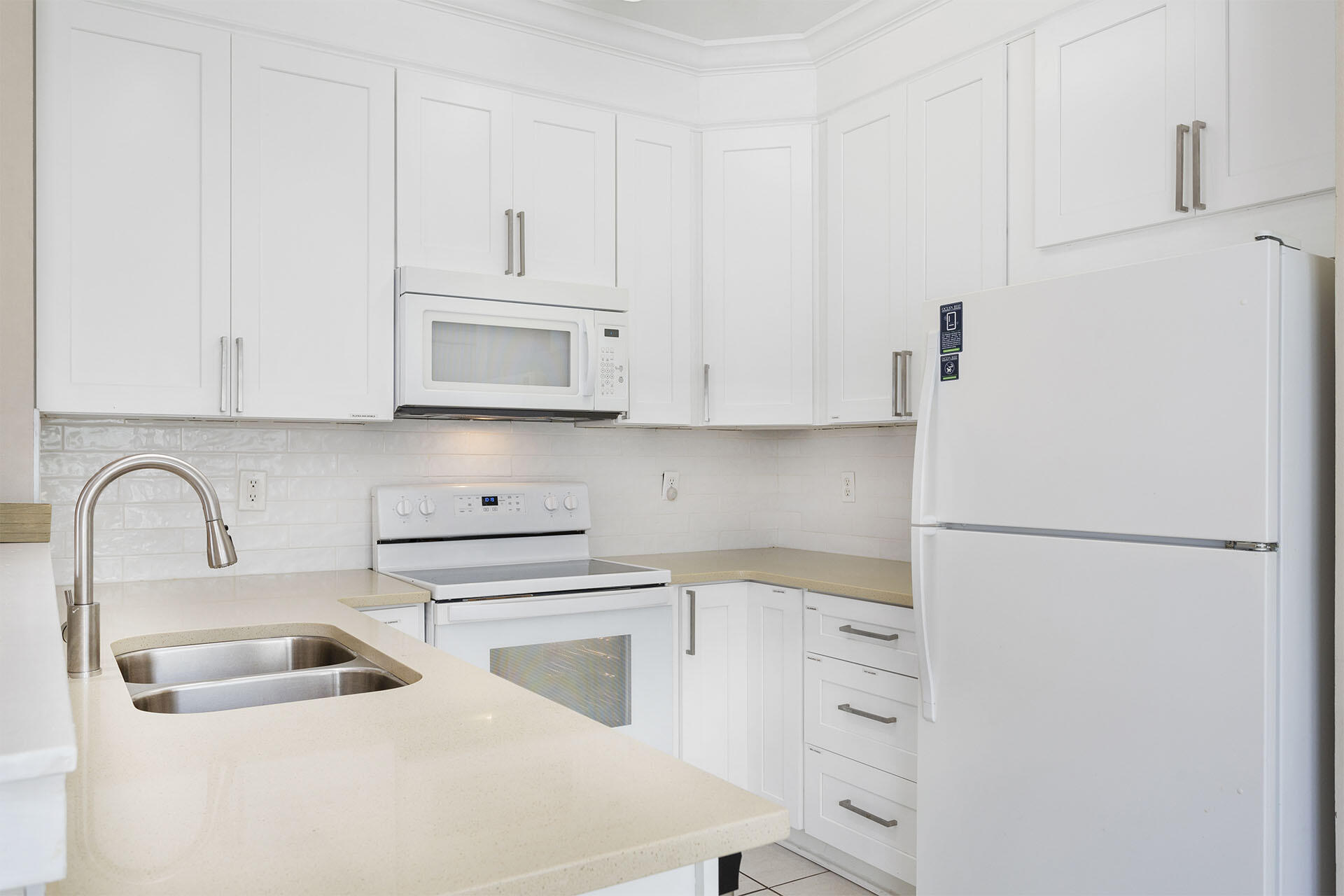 20 Sandy Beach Road Miramar Beach, FL 32550 - Photo 32 of 42 a white kitchen with sink a refrigerator and cabinets