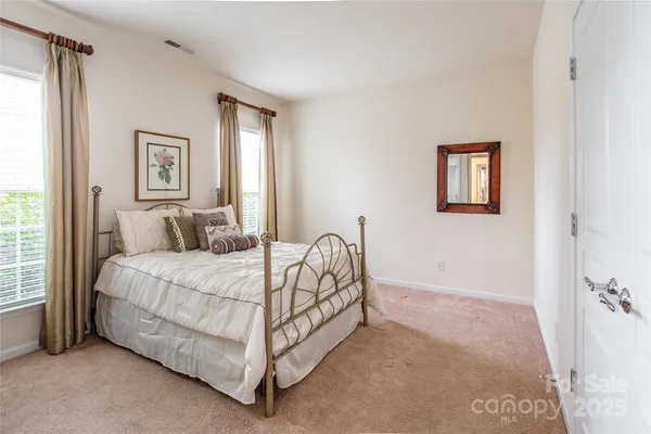 a bed sitting in a bedroom next to a window