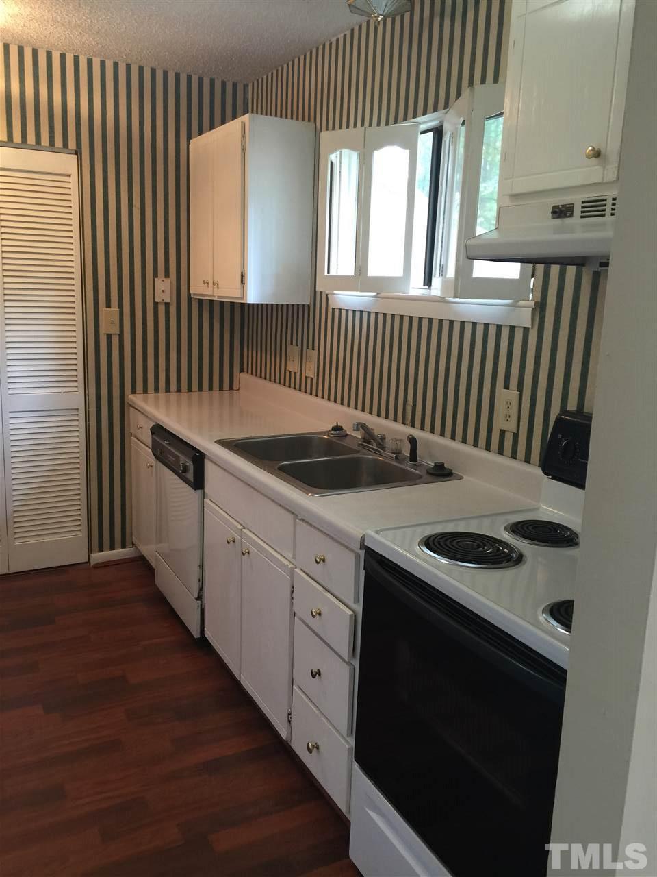 706 Godwin Court Raleigh, NC 27606 - Photo 3 of 19 a kitchen with granite countertop a stove a sink and a window