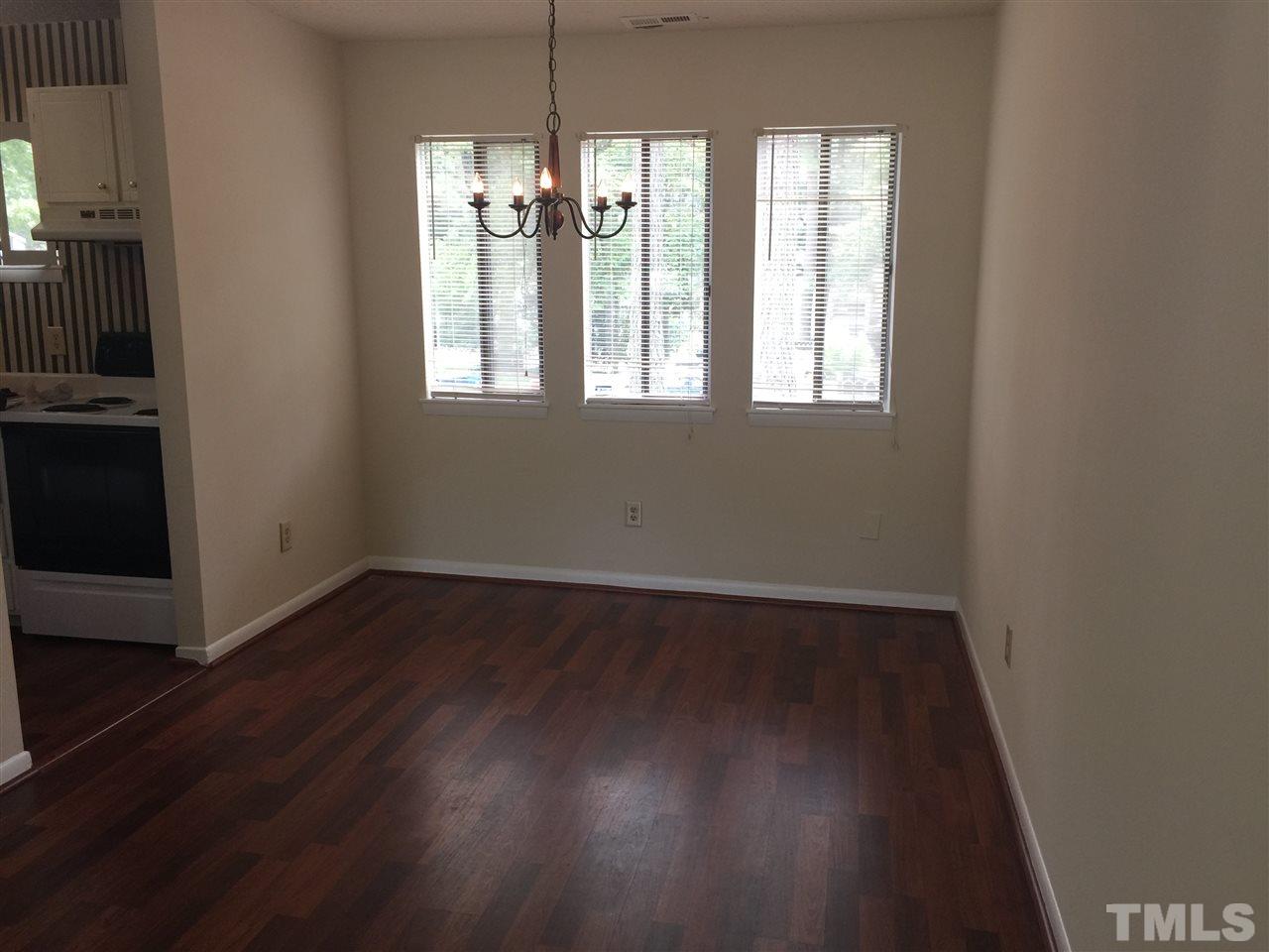 706 Godwin Court Raleigh, NC 27606 - Photo 6 of 19 an empty room with wooden floor and windows