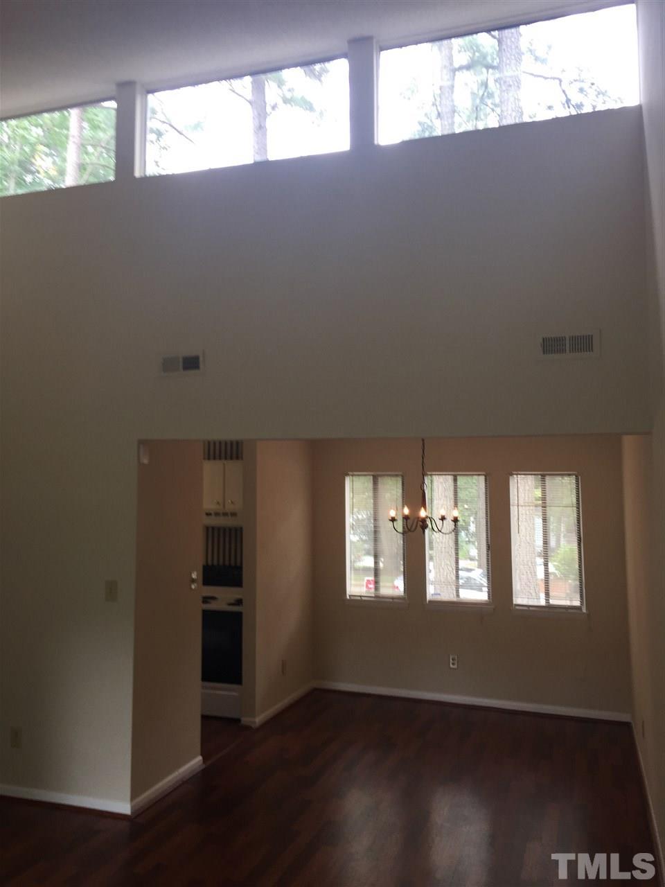 706 Godwin Court Raleigh, NC 27606 - Photo 7 of 19 a view of an empty room with wooden floor and a window