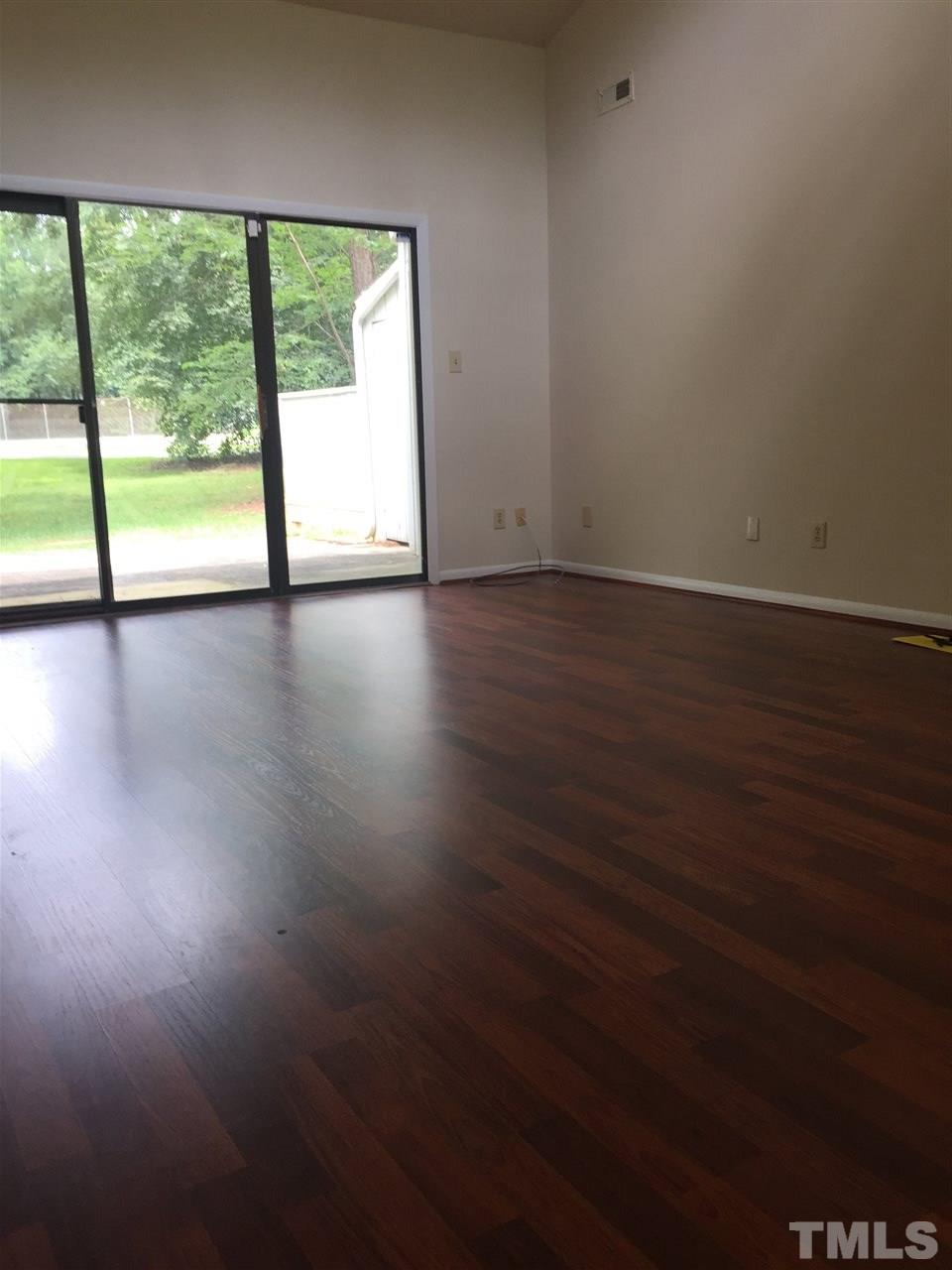 706 Godwin Court Raleigh, NC 27606 - Photo 8 of 19 a view of an empty room with wooden floor and a window