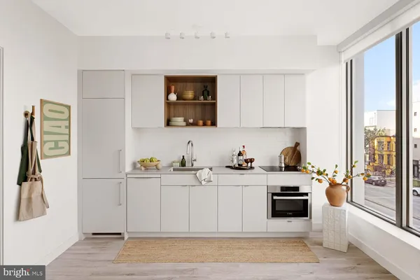 a kitchen with stainless steel appliances a sink a stove a refrigerator wooden floor and cabinets