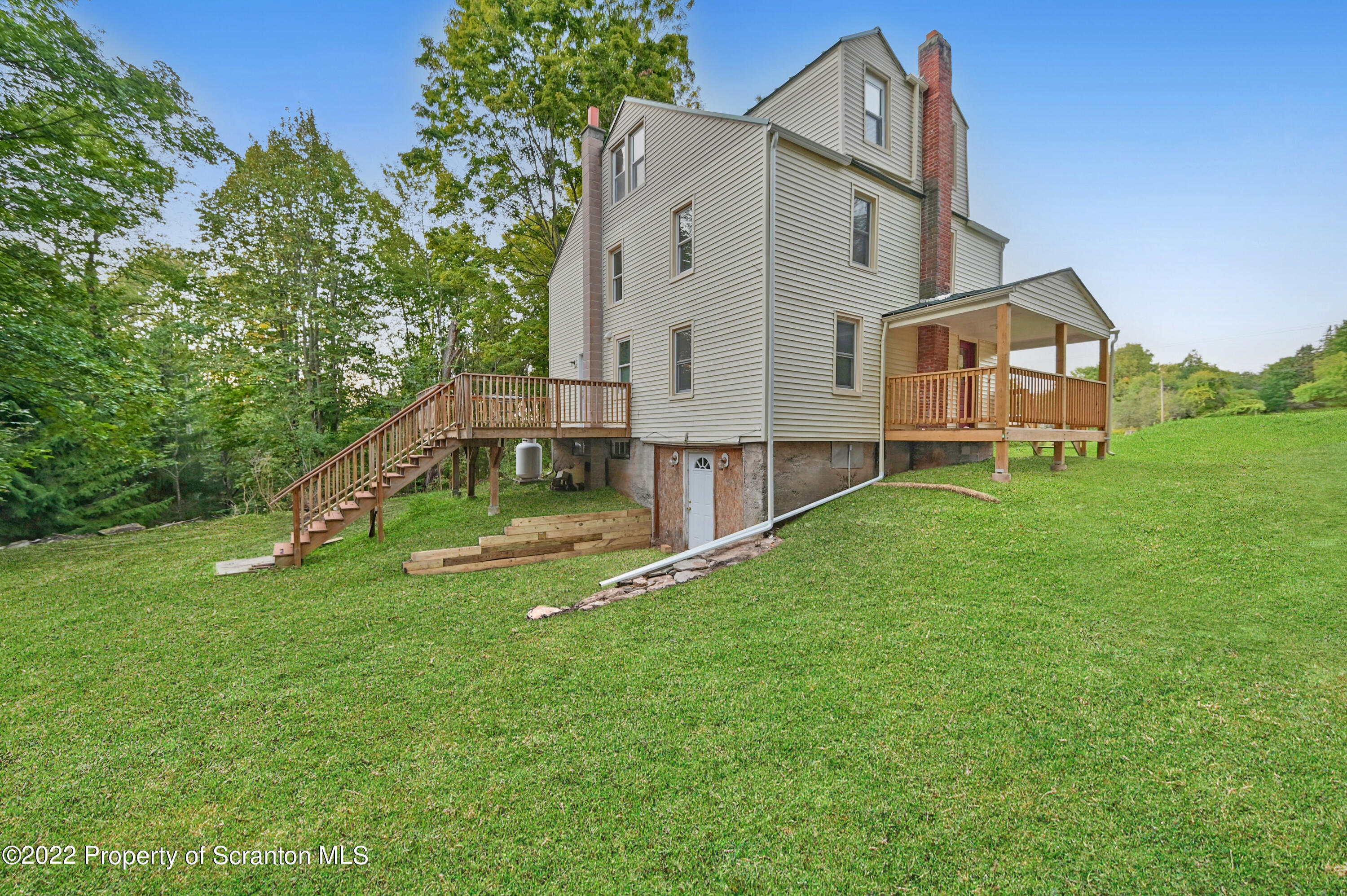 549 Gravity Road Lake Ariel, PA 18436 - Photo 8 of 62 a house that is sitting in the grass with large trees