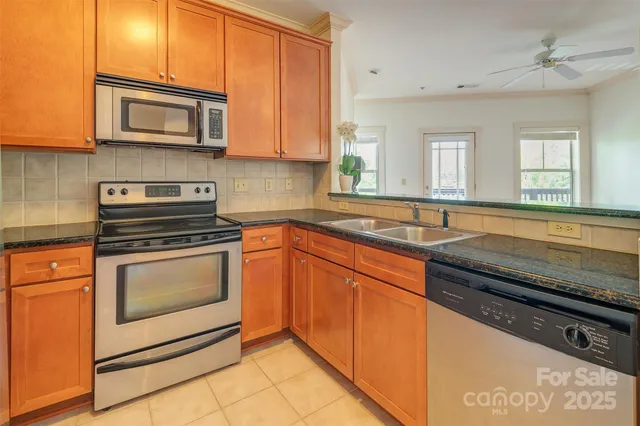 a kitchen with stainless steel appliances granite countertop a sink stove and microwave