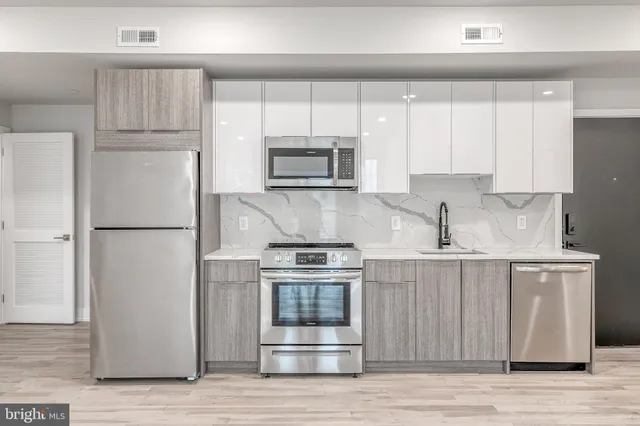 a kitchen with wooden cabinets and stainless steel appliances