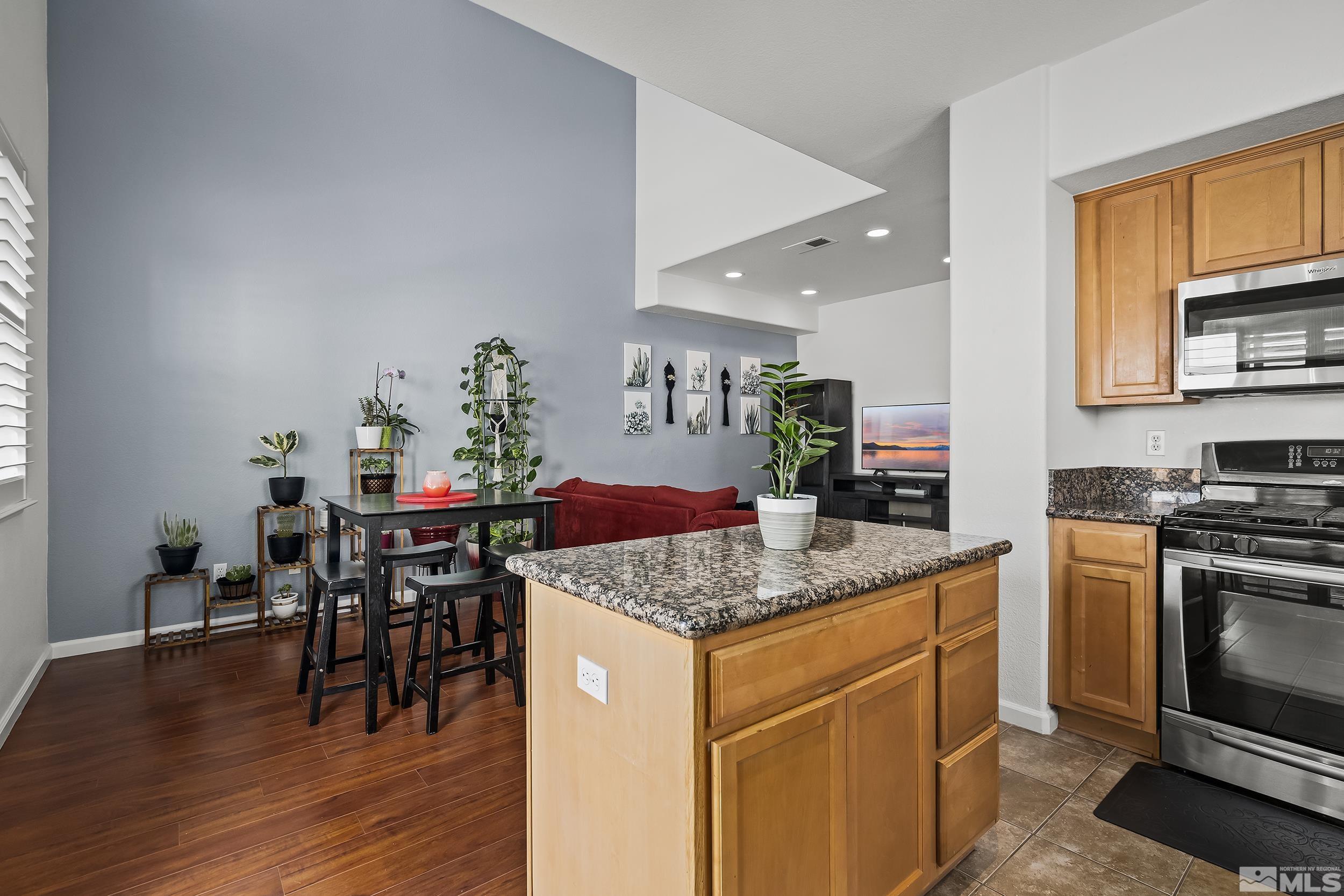 2115 Stanton Lane Reno, NV 89502 - Photo 8 of 18 a kitchen with stainless steel appliances granite countertop a stove top oven a sink a dining table and chairs with wooden floor