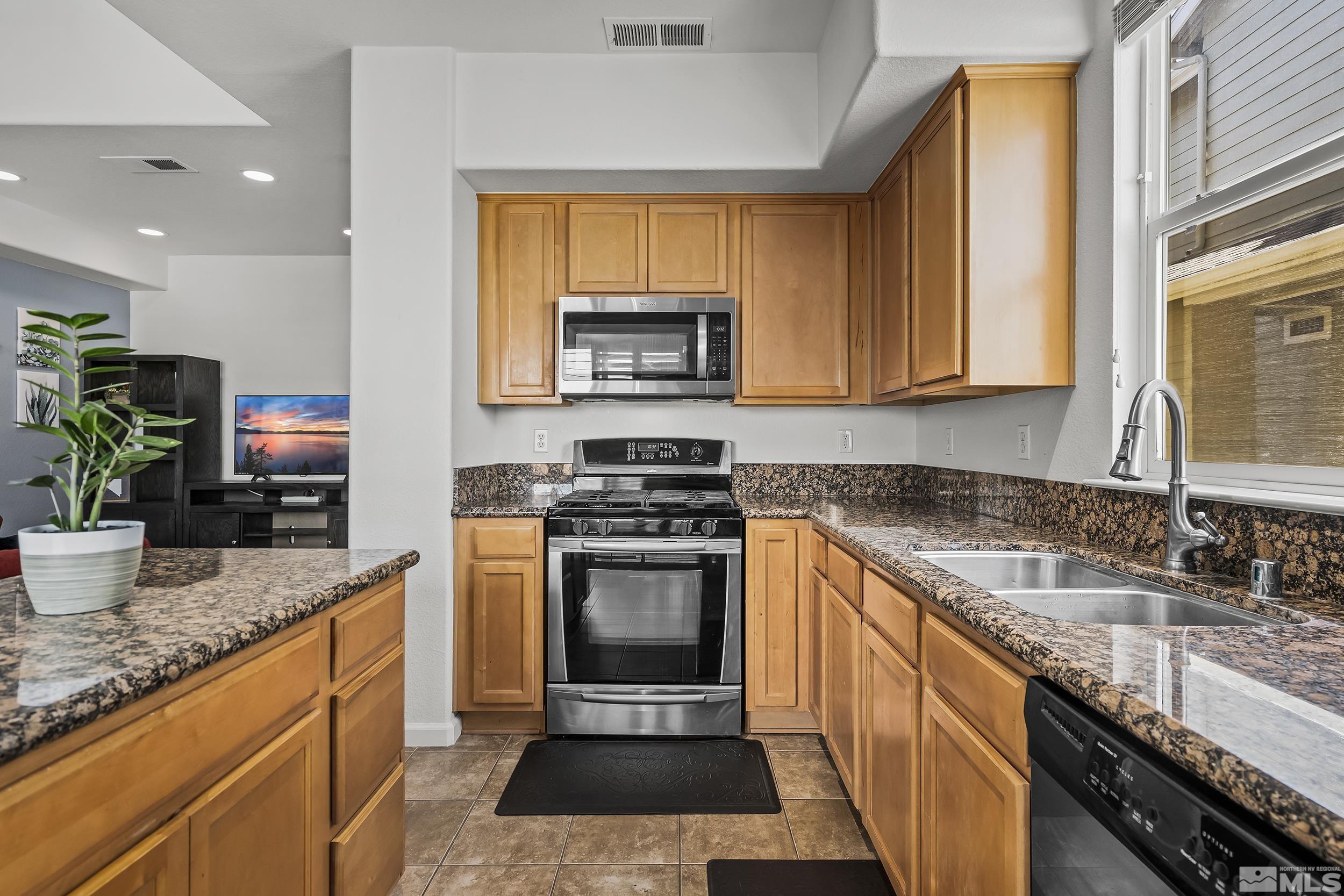 2115 Stanton Lane Reno, NV 89502 - Photo 9 of 18 a kitchen with granite countertop a sink a stove top oven a counter space and cabinets