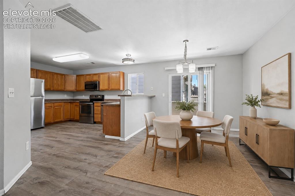 431 Kitfield View Colorado Springs, CO 80916 - Photo 6 of 27 a kitchen with refrigerator a sink and chairs