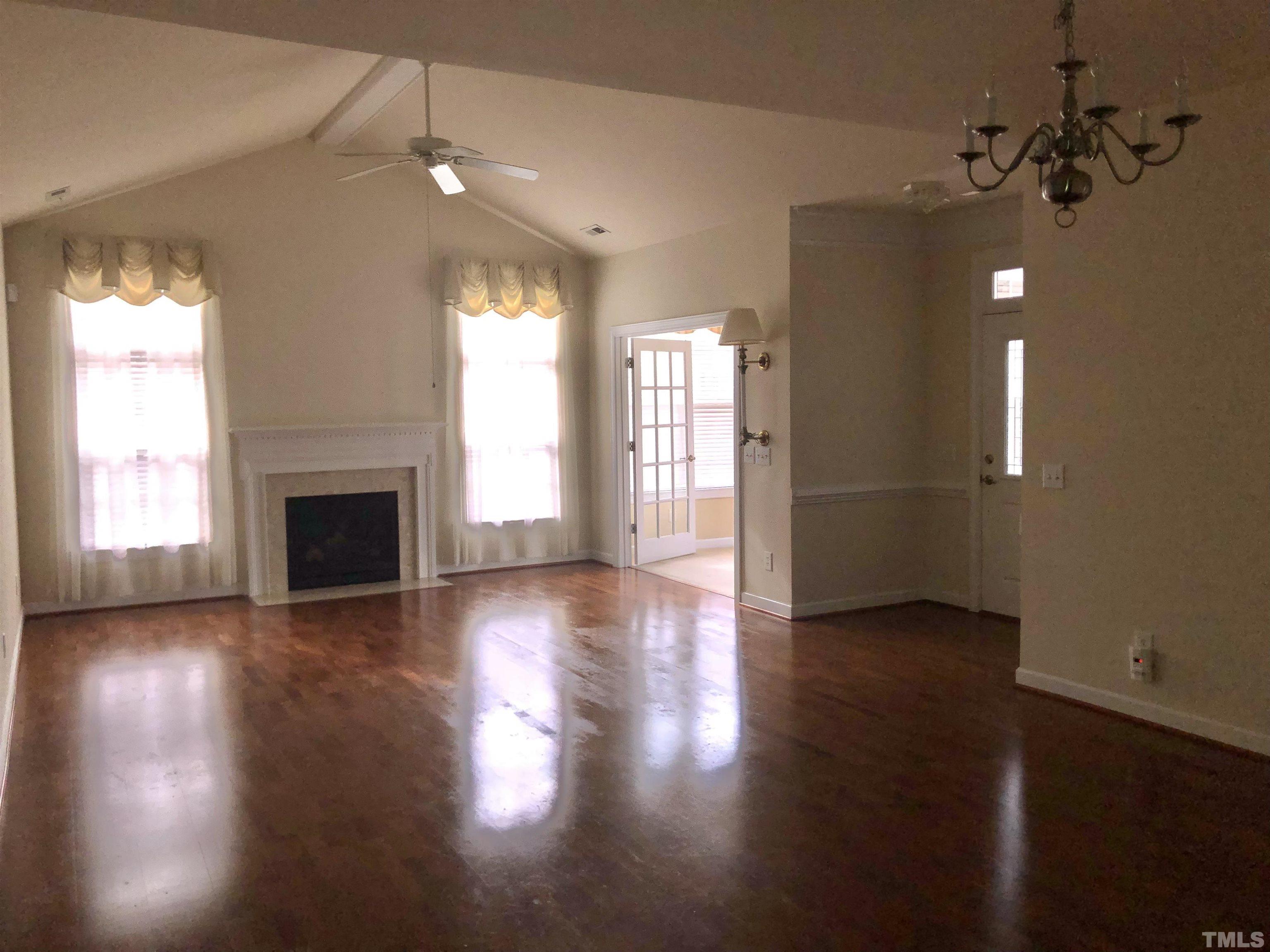 4720 Fox Fern Lane Raleigh, NC 27604 - Photo 8 of 20 an empty room with wooden floor fireplace and windows