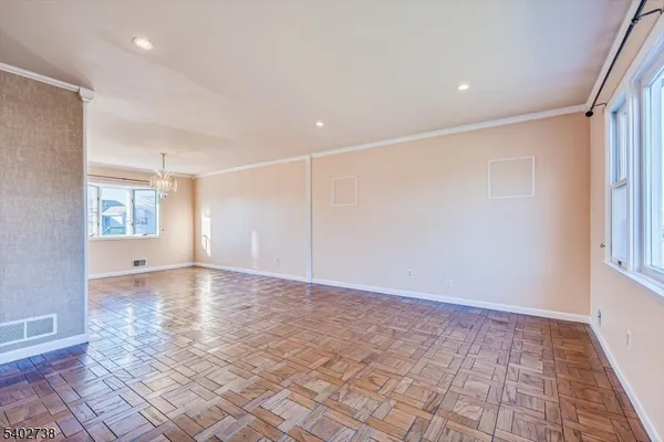 an empty room with windows and chandelier