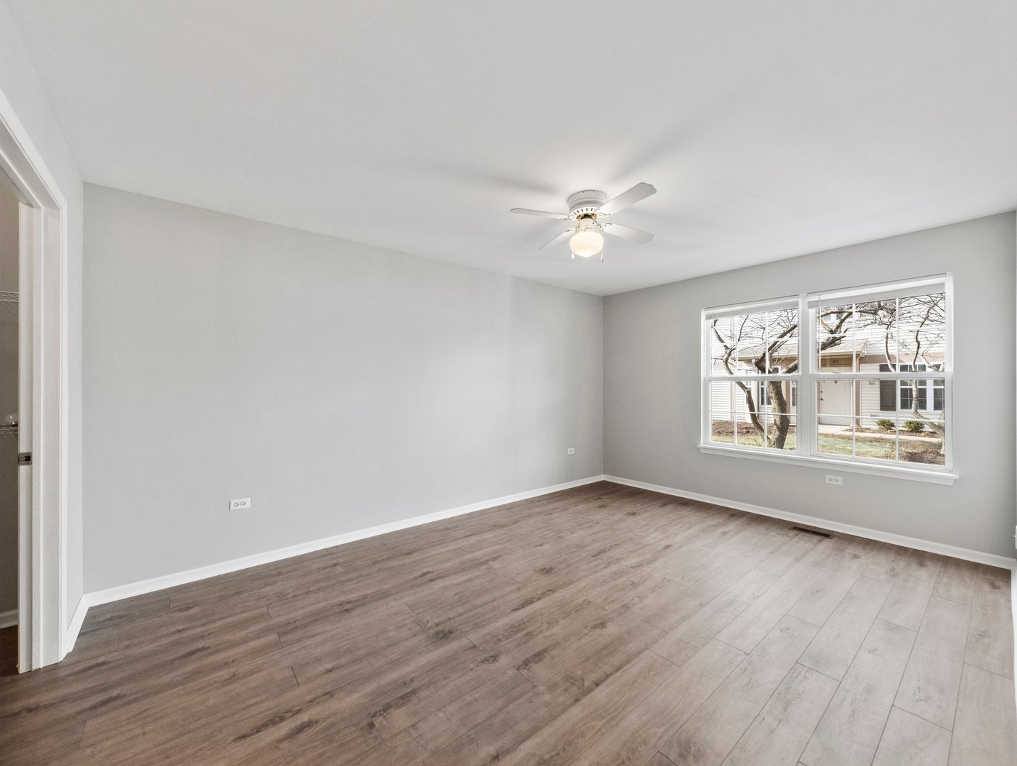 2503 Sheehan Drive, Unit 101 Naperville, IL 60564 - Photo 12 of 19 wooden floor in an empty room with a window