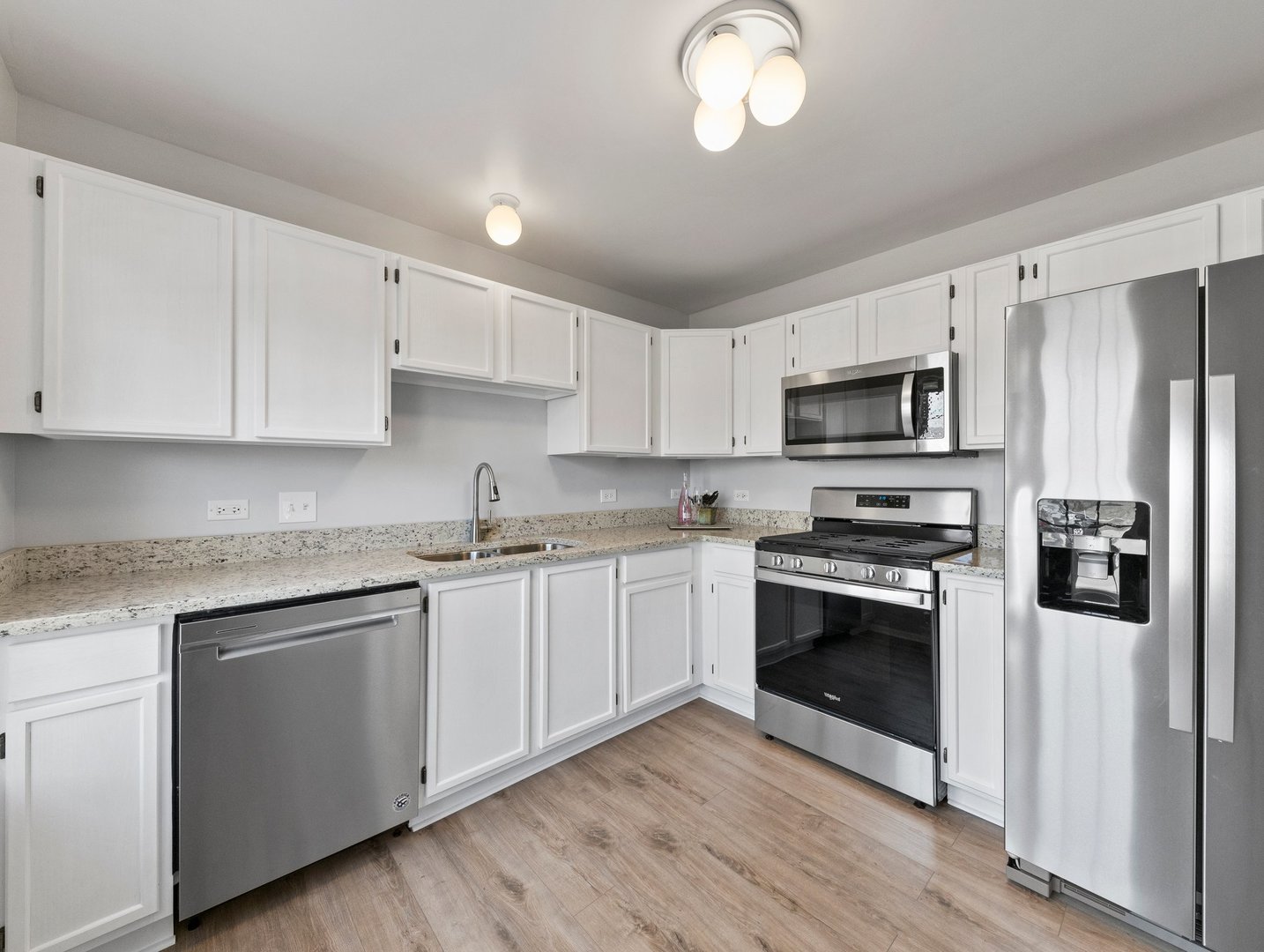 2503 Sheehan Drive, Unit 101 Naperville, IL 60564 - Photo 7 of 19 a kitchen with stainless steel appliances granite countertop a stove a sink dishwasher a refrigerator and a microwave oven with wooden floor