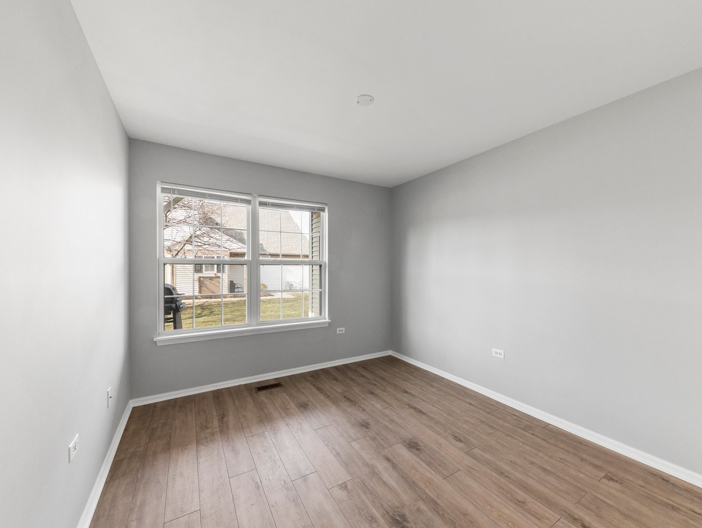 2503 Sheehan Drive, Unit 101 Naperville, IL 60564 - Photo 9 of 19 an empty room with wooden floor and windows