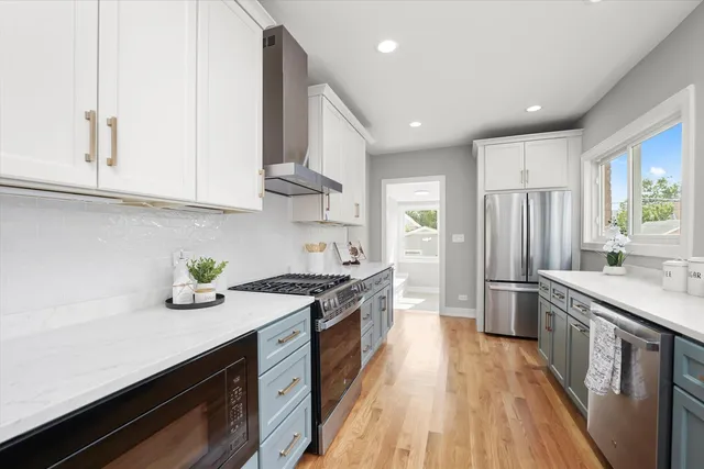 a kitchen with stainless steel appliances sink stove refrigerator and cabinets