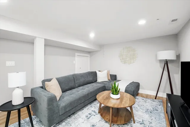 a living room with furniture a window and a lamp