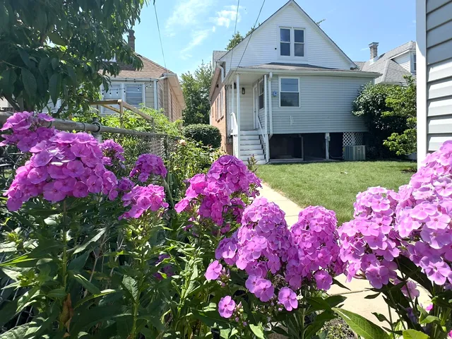 a front view of small house with yard and fountain