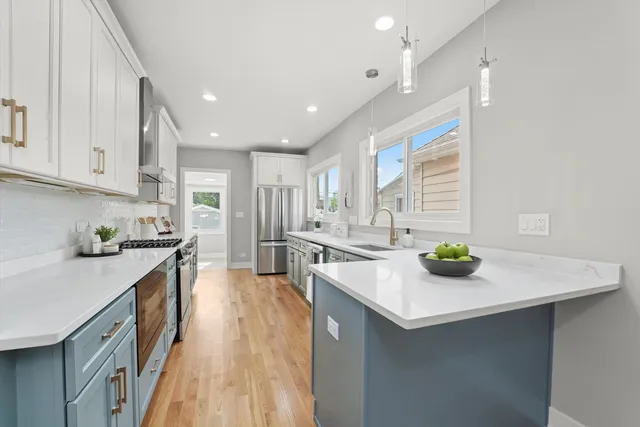 a kitchen with stainless steel appliances a sink a stove top oven a counter space and cabinets