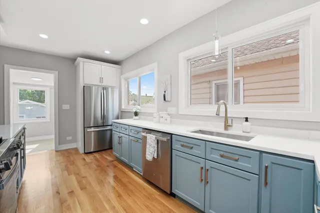 a kitchen with stainless steel appliances granite countertop a sink stove and refrigerator