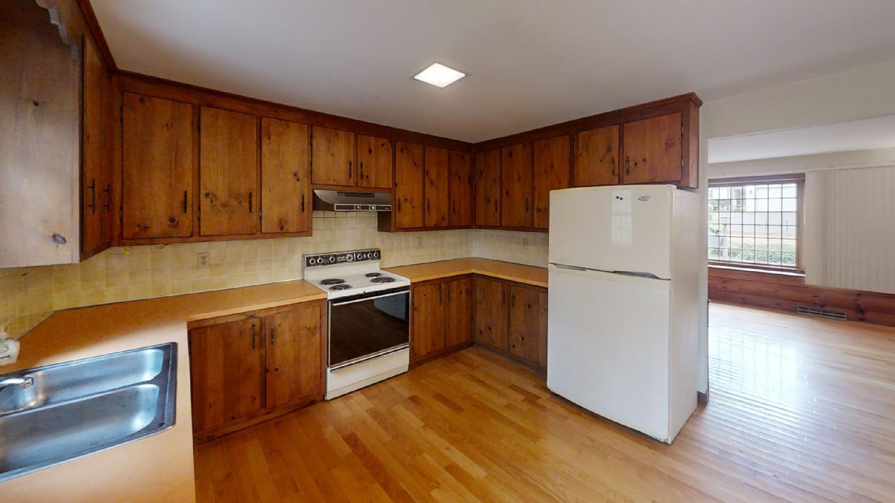 6 Old Hills Road Dennis, MA 02638 - Photo 13 of 45 a kitchen with a refrigerator a stove top oven a wooden floor and cabinets