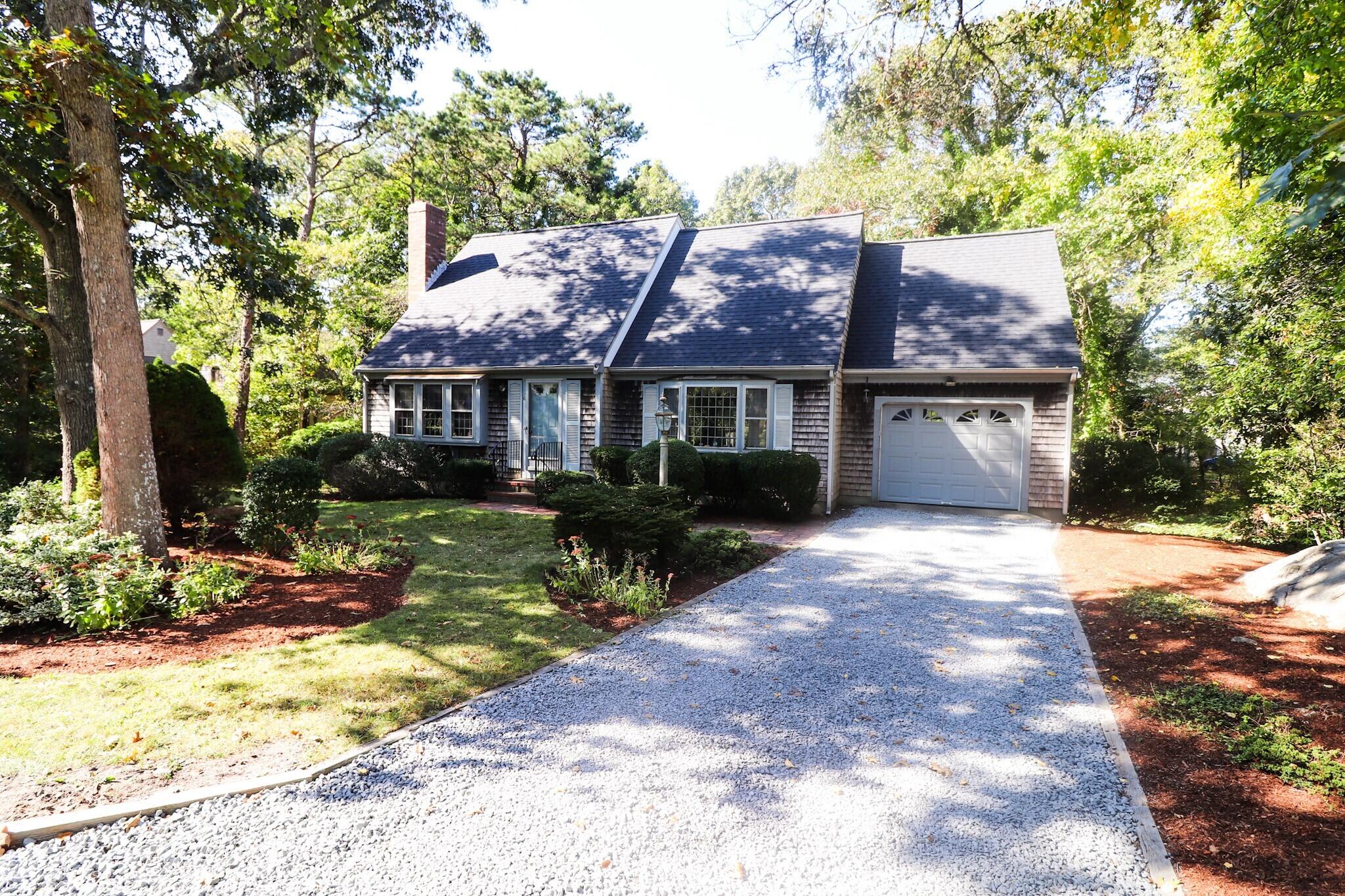 6 Old Hills Road Dennis, MA 02638 - Photo 26 of 45 a front view of a house with a garden and trees