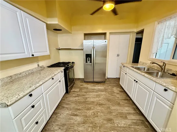 a large kitchen with granite countertop a sink and cabinets
