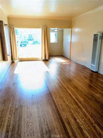 a view of a room with wooden floor and a window