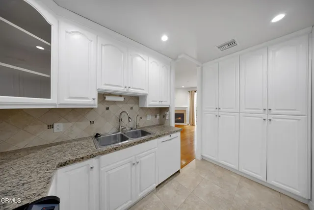a kitchen with granite countertop white cabinets and sink