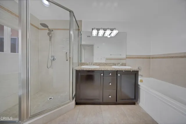 a bathroom with a granite countertop sink a mirror and shower