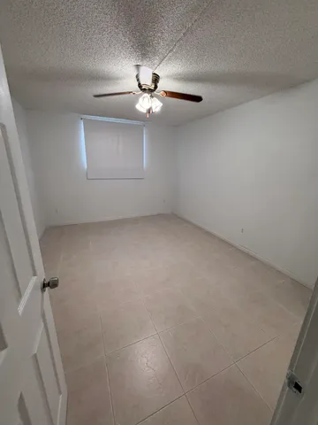 an empty room with a ceiling fan and hardwood floor