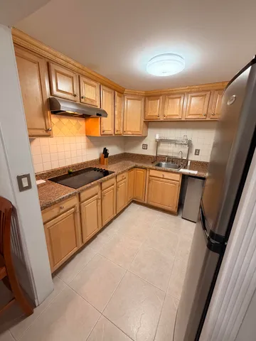 a kitchen with stainless steel appliances granite countertop a sink stove and cabinets