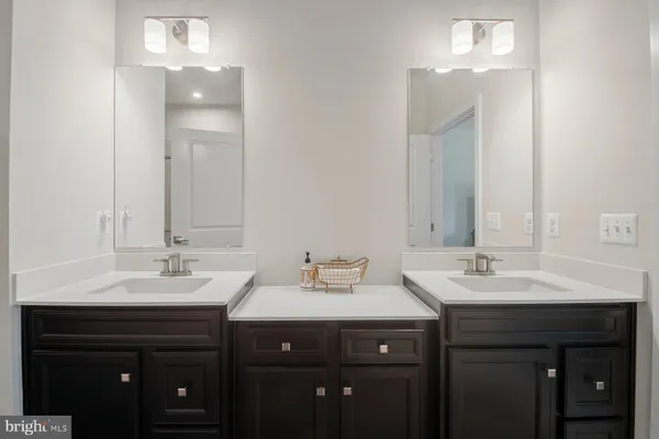 a bathroom with double sink and a mirror