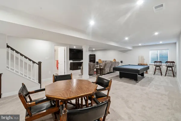 a living room with furniture a table and kitchen view