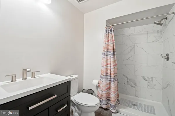 a bathroom with a sink a toilet and shower