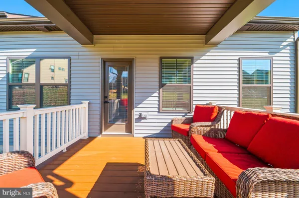 a view of a patio with couches chairs and wooden floor