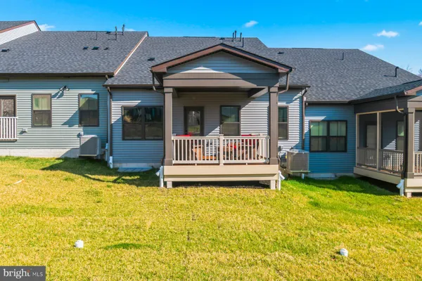 a view of a house with pool and chairs next to a yard