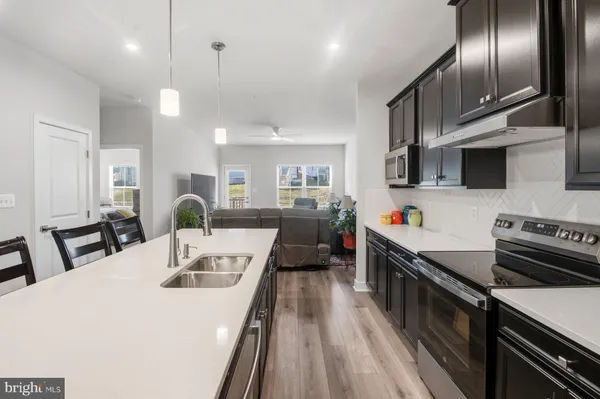 a kitchen with counter space appliances and wooden floor